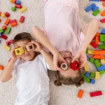 bovenaanzicht-niet-binaire-kinderen-spelen-met-een-kleurrijk-spel_freepik